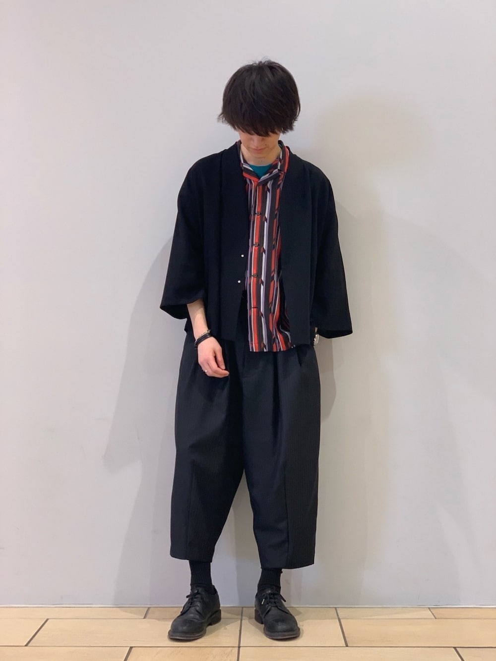 ブラック系のノーカラージャケット、オレンジ系のシャツ/ブラウス、ブラック系のスラックスを着用したメンズの春コーディネートの1枚目の写真