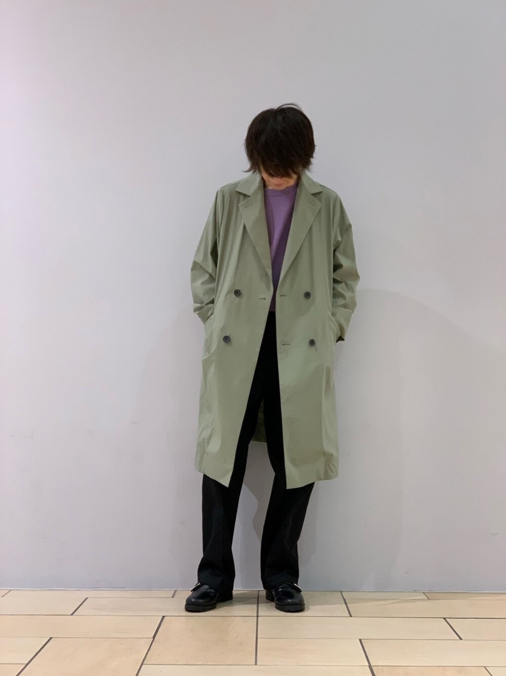 パープル系のTシャツ/カットソー、グリーン系のトレンチコート、ブラック系のチノパンツを着用したメンズの冬コーディネートの1枚目の写真