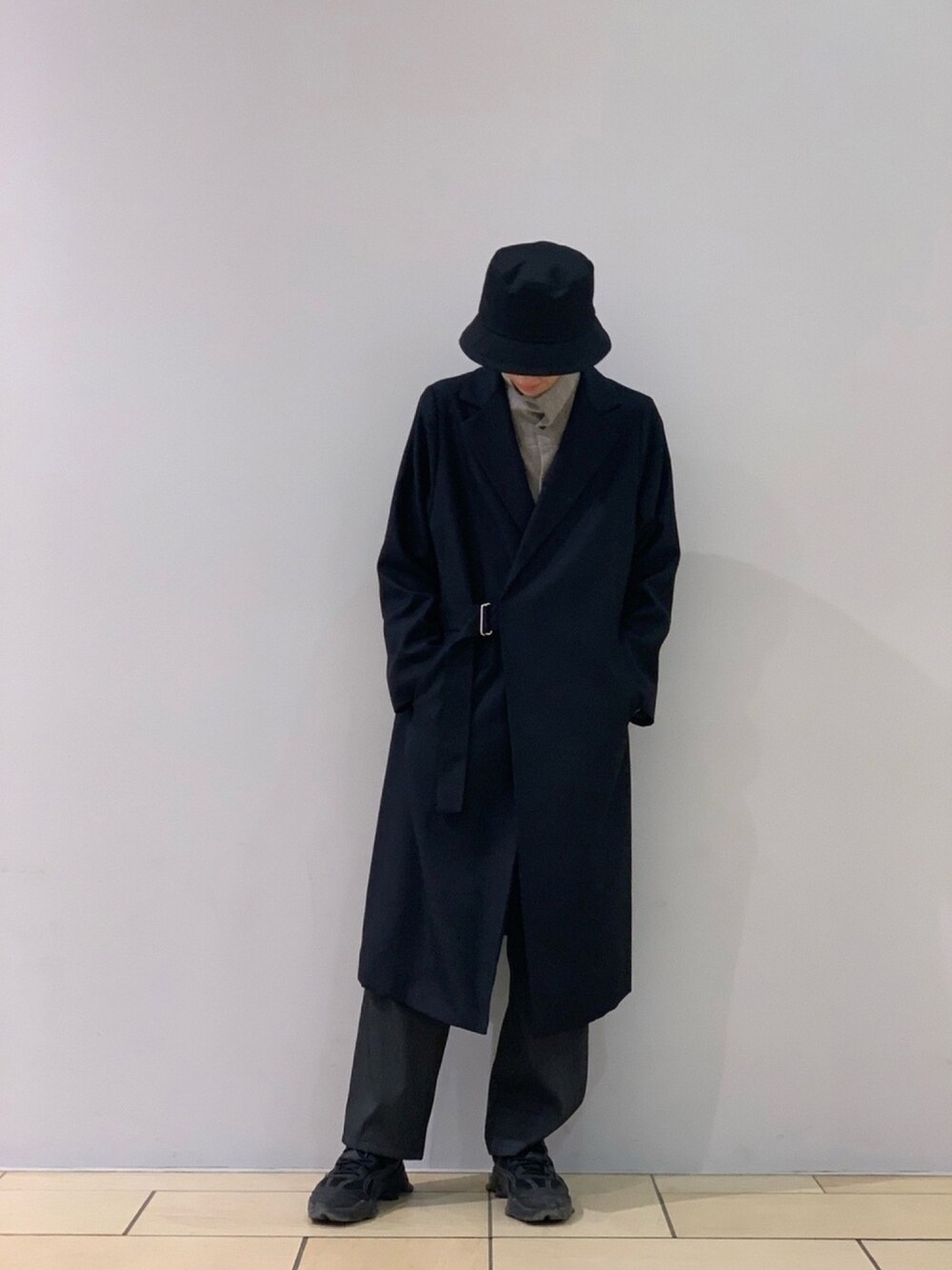 グレー系のシャツ/ブラウス、ブルー系のトレンチコート、ブラック系のハットを着用したメンズの秋コーディネートの1枚目の写真