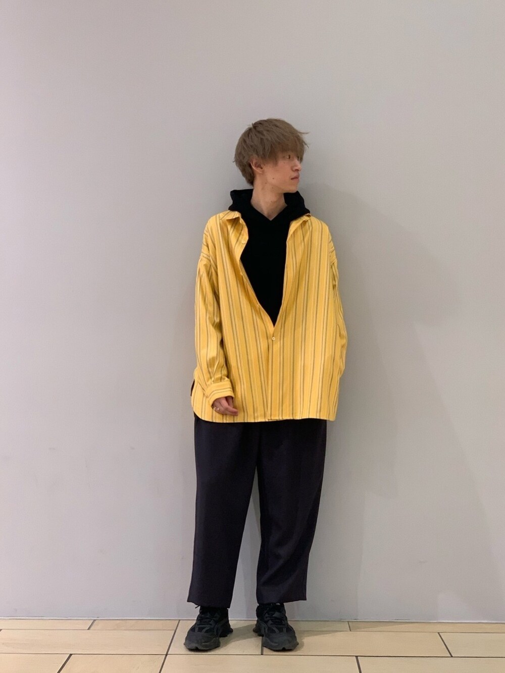 イエロー系のシャツ/ブラウス、グレー系のスラックス、ブラック系のパーカーを着用したメンズの冬コーディネートの1枚目の写真