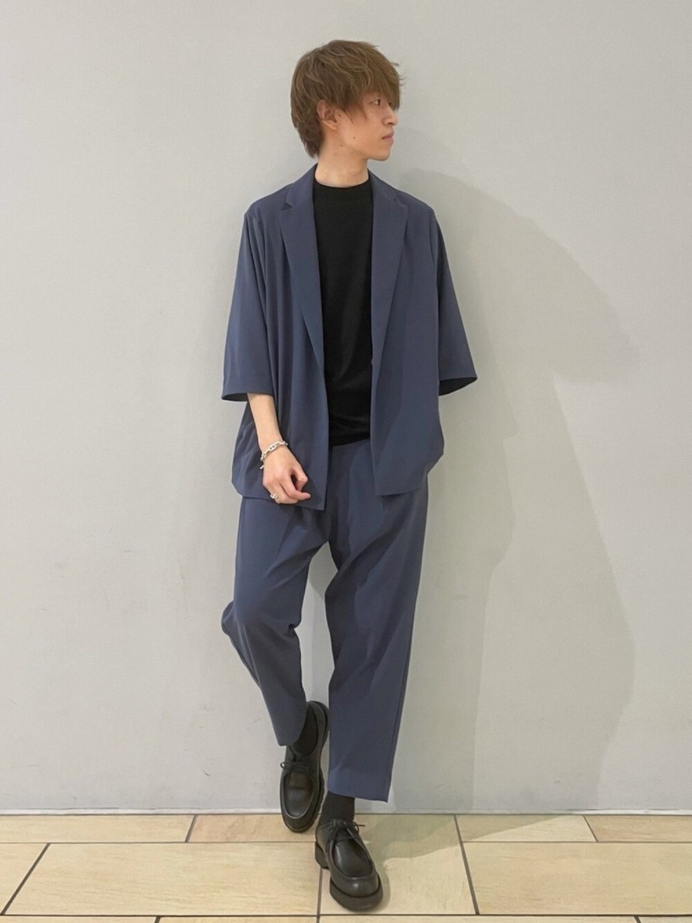 ブラック系のTシャツ/カットソー、ブルー系のテーラードジャケット、ブルー系のスラックスを着用したメンズの春コーディネートの1枚目の写真