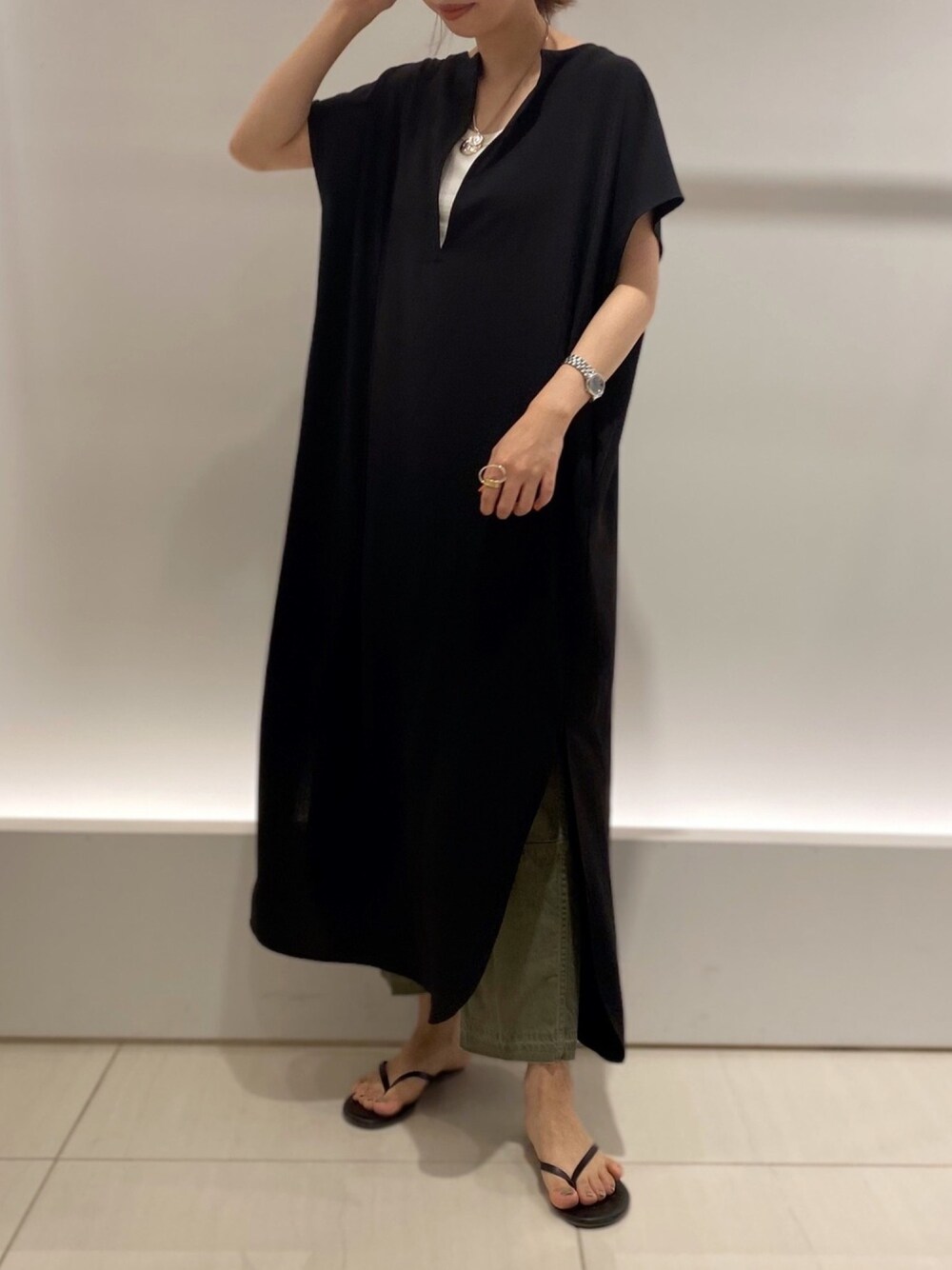 ブラック系のワンピース、グリーン系のTシャツ/カットソー、グリーン系のパンツを着用したレディースの春コーディネートの1枚目の写真