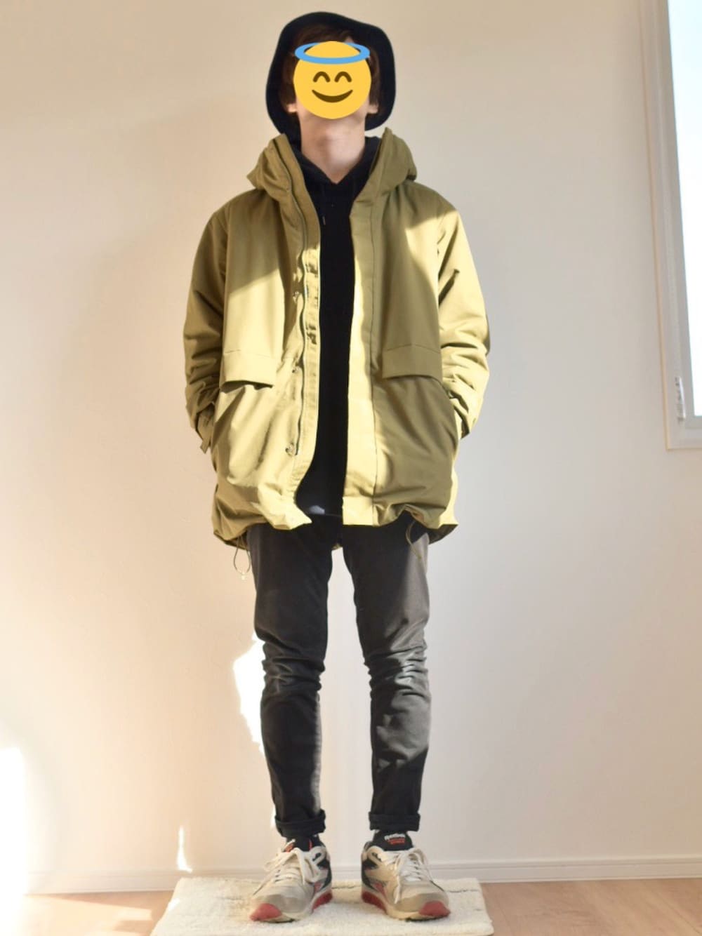 グリーン系のブルゾン、ブルー系のパーカー、ブラック系のデニムパンツを着用したメンズの冬コーディネートの1枚目の写真