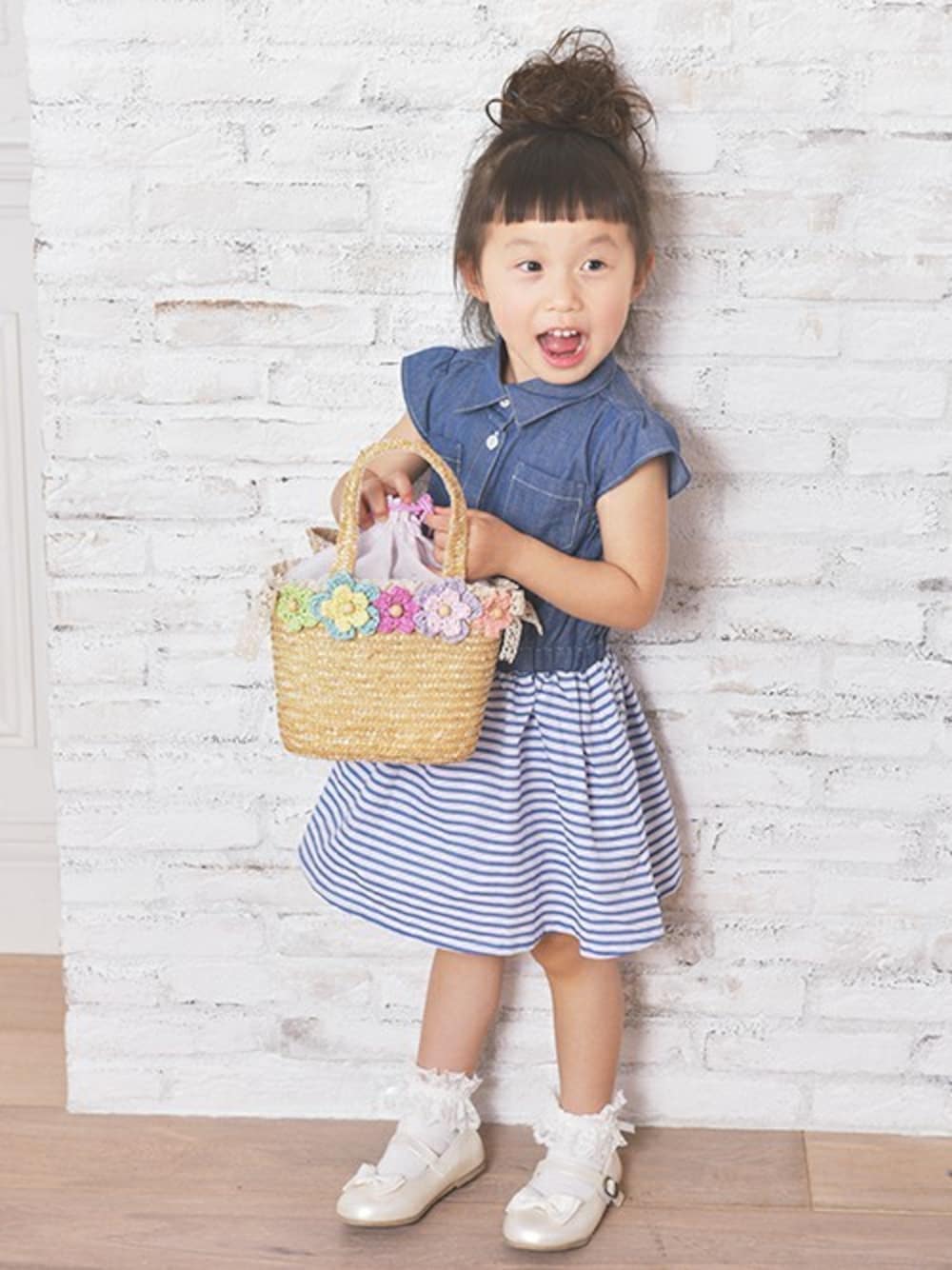 ブルー系のシャツワンピースを着用したキッズの春コーディネートの1枚目の写真
