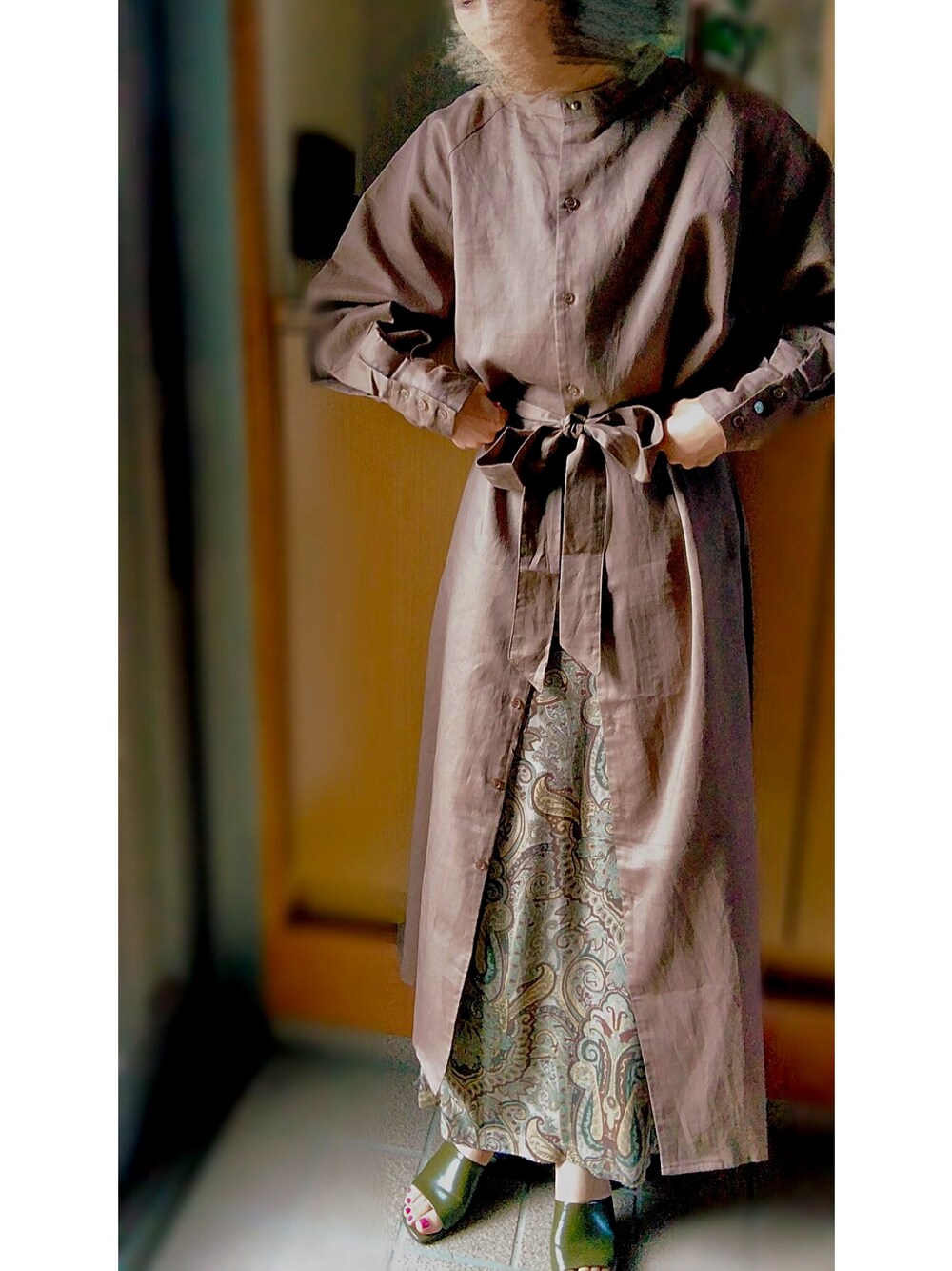 ブラウン系のシャツワンピース、グリーン系のスカート、グリーン系のサンダルを着用したレディースの秋コーディネートの1枚目の写真