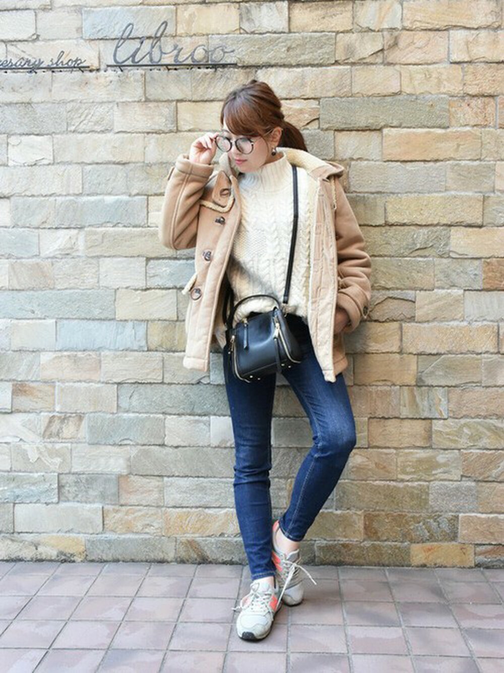 ブラック系のハンドバッグ、ブラック系のピアス(両耳用)を着用したレディースの冬コーディネートの1枚目の写真