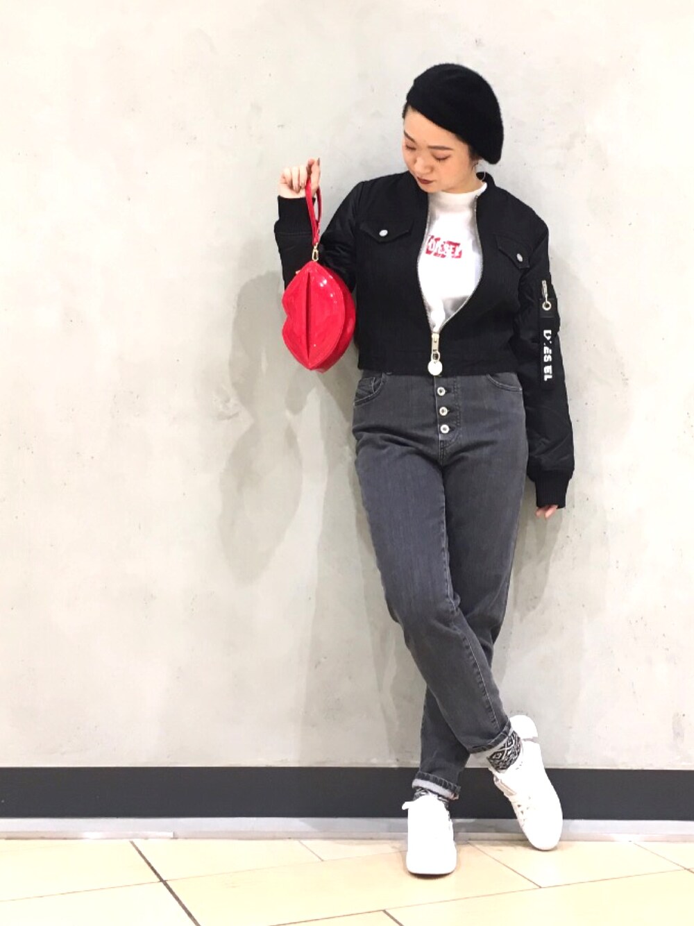 レッド系のクラッチバッグ、ホワイト系のTシャツ/カットソー、ブラック系のブルゾンを着用したレディースの冬コーディネートの1枚目の写真
