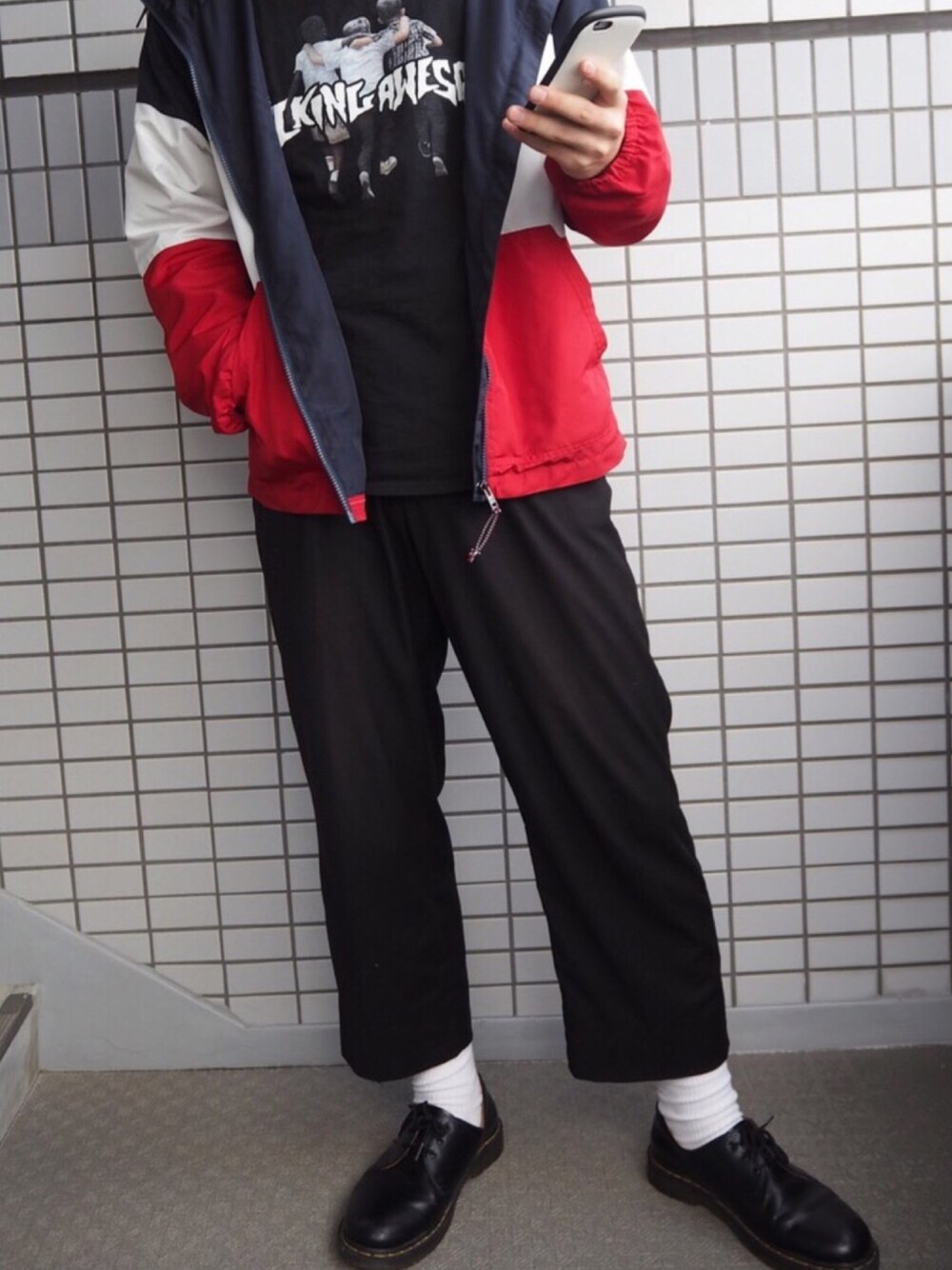 ブラック系のスラックス、ブラック系のブーツ、レッド系のナイロンジャケットを着用したメンズの冬コーディネートの1枚目の写真