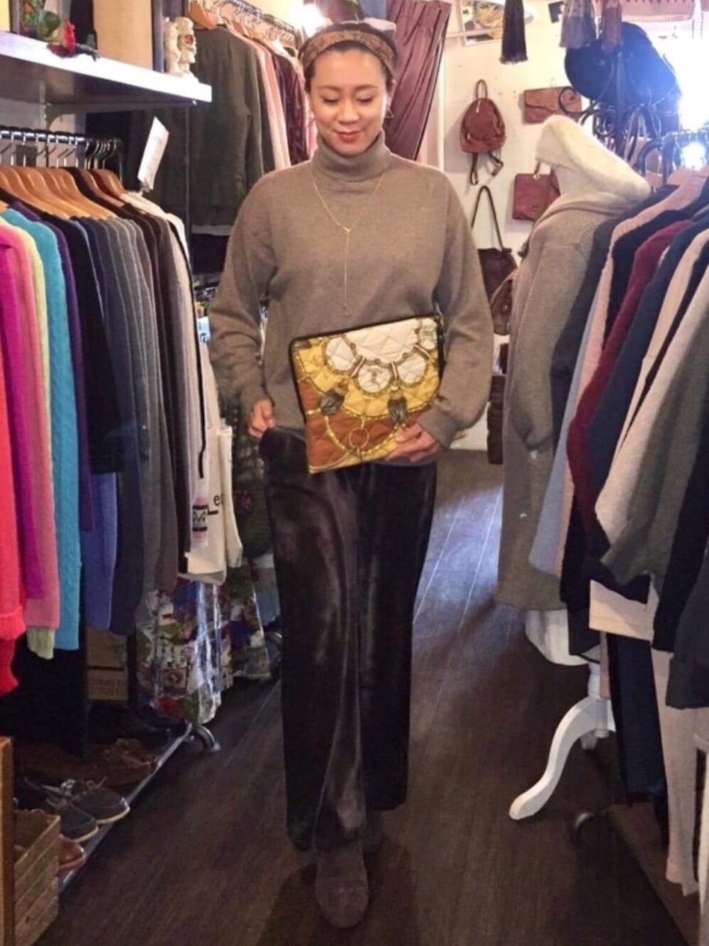 その他のクラッチバッグ、ベージュ系のニット/セーター、ブラウン系のその他パンツを着用したレディースの冬コーディネートの1枚目の写真