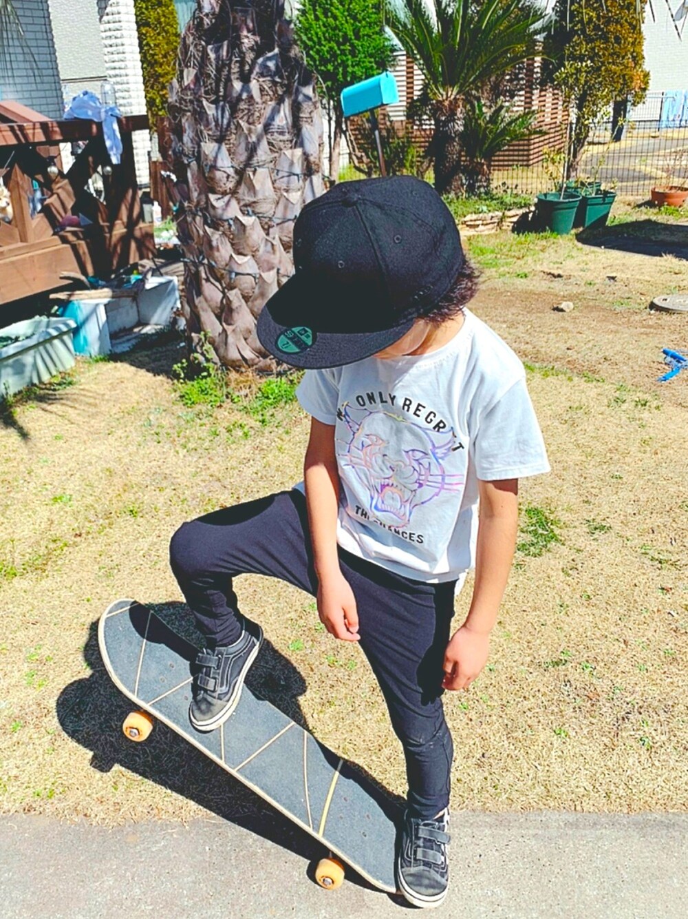 ホワイト系のTシャツ/カットソー、ブラック系のスニーカー、ブラック系のキャップを着用したキッズの春コーディネートの1枚目の写真