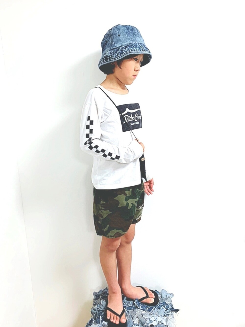 ホワイト系のTシャツ/カットソー、グリーン系のパンツ、ブラック系のサンダルを着用したキッズの春コーディネートの1枚目の写真
