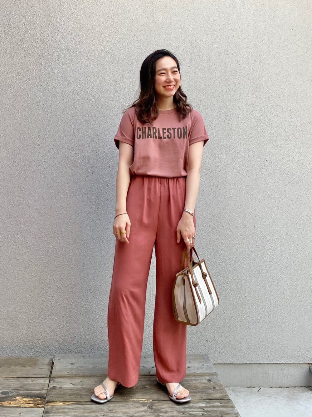 ピンク系のTシャツ/カットソー、ピンク系のその他パンツ、ベージュ系のショルダーバッグを着用したレディースの秋コーディネートの1枚目の写真