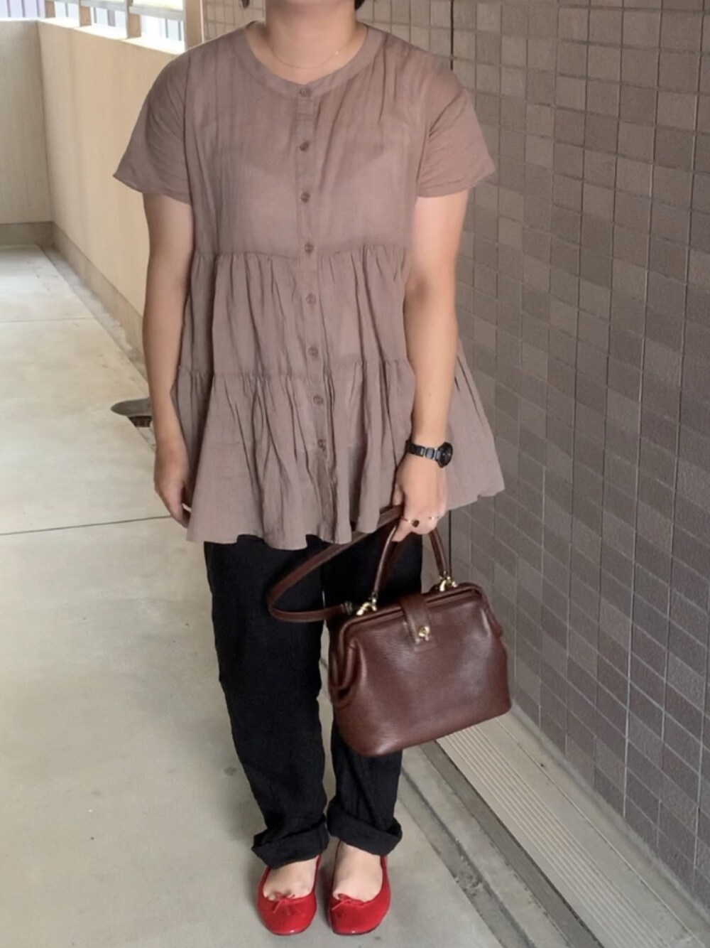レッド系のパンプス、ブラウン系のバッグ、ブラウン系のシャツ/ブラウスを着用したレディースの夏コーディネートの1枚目の写真