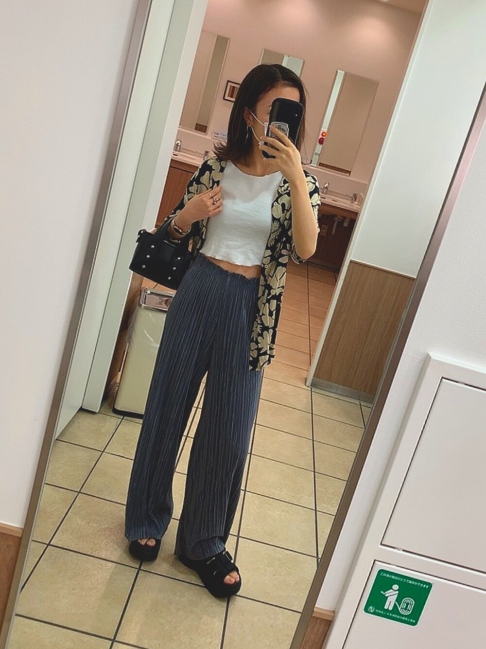 ブルー系のその他パンツ、ブラック系のハンドバッグ、ブラック系のサンダルを着用したレディースの夏コーディネートの1枚目の写真