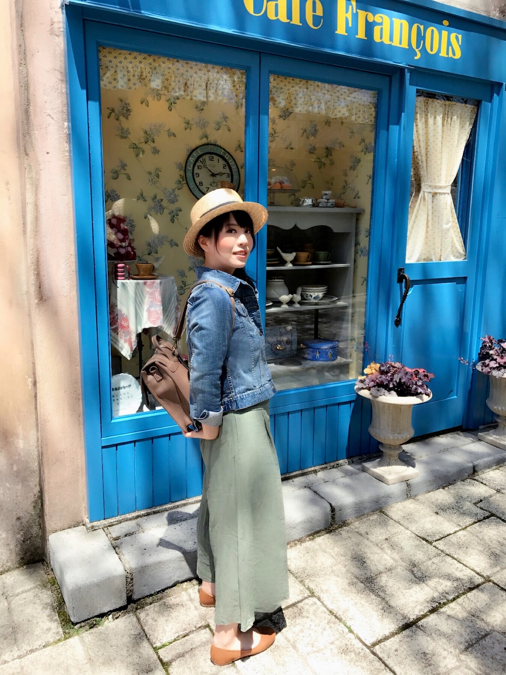 ブルー系のデニムジャケット、グリーン系のパンツ、オレンジ系のパンプスを着用したレディースの春コーディネートの1枚目の写真