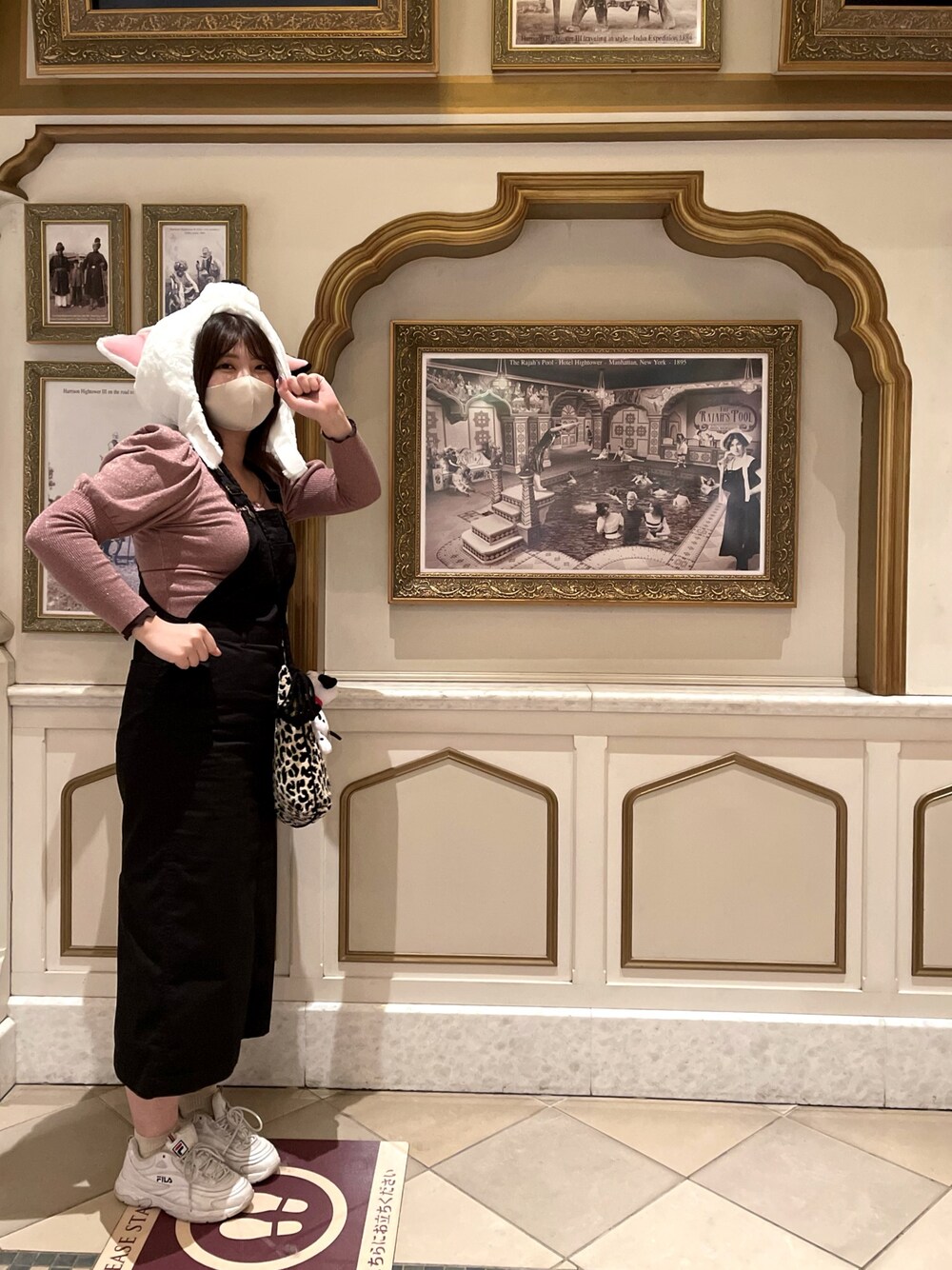 ピンク系のカーディガン/ボレロ、ブラック系のジャンパースカート、ベージュ系のショルダーバッグを着用したレディースの秋コーディネートの1枚目の写真