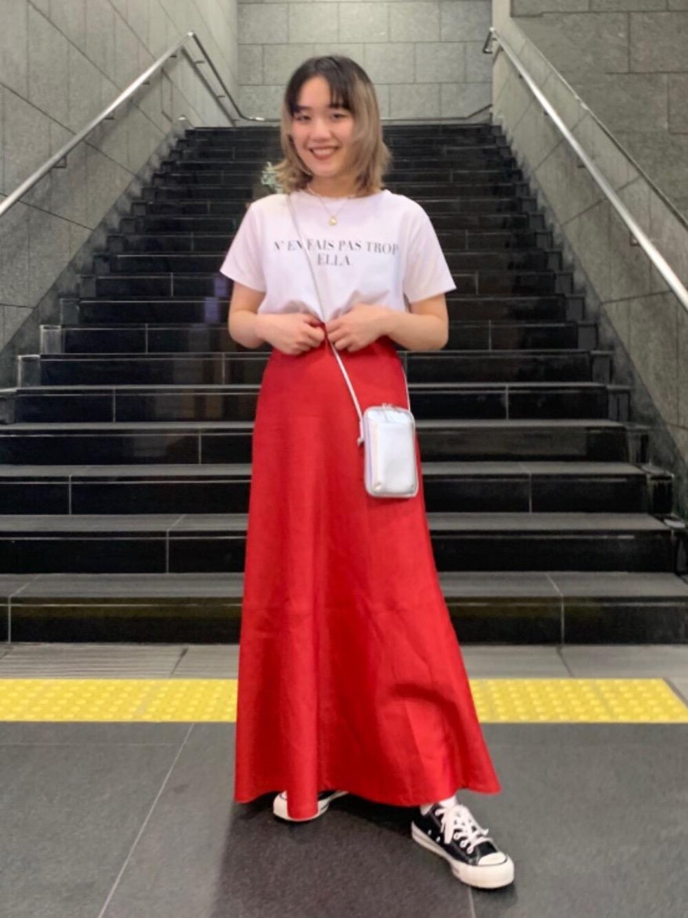 ブラック系のスニーカー、ホワイト系のTシャツ/カットソー、レッド系のスカートを着用したレディースの春コーディネートの1枚目の写真