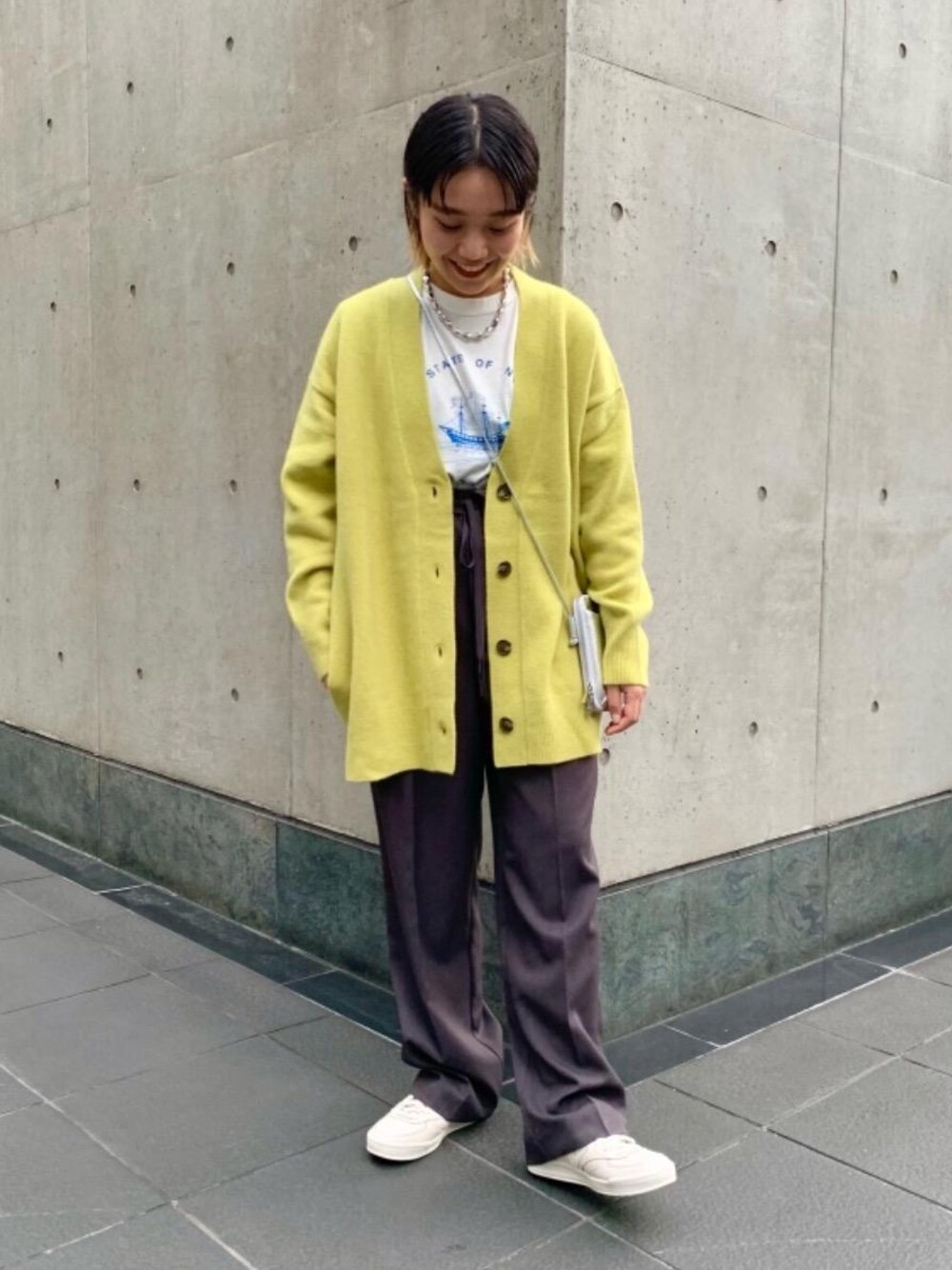 ホワイト系のTシャツ/カットソー、ホワイト系のスニーカー、グレー系のその他パンツを着用したレディースの秋コーディネートの1枚目の写真