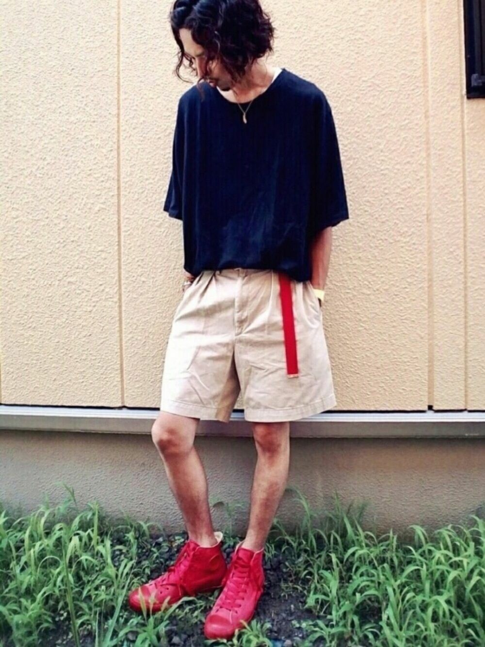 ベージュ系のパンツ、ブラック系のTシャツ/カットソー、レッド系のスニーカーを着用したメンズの夏コーディネートの1枚目の写真