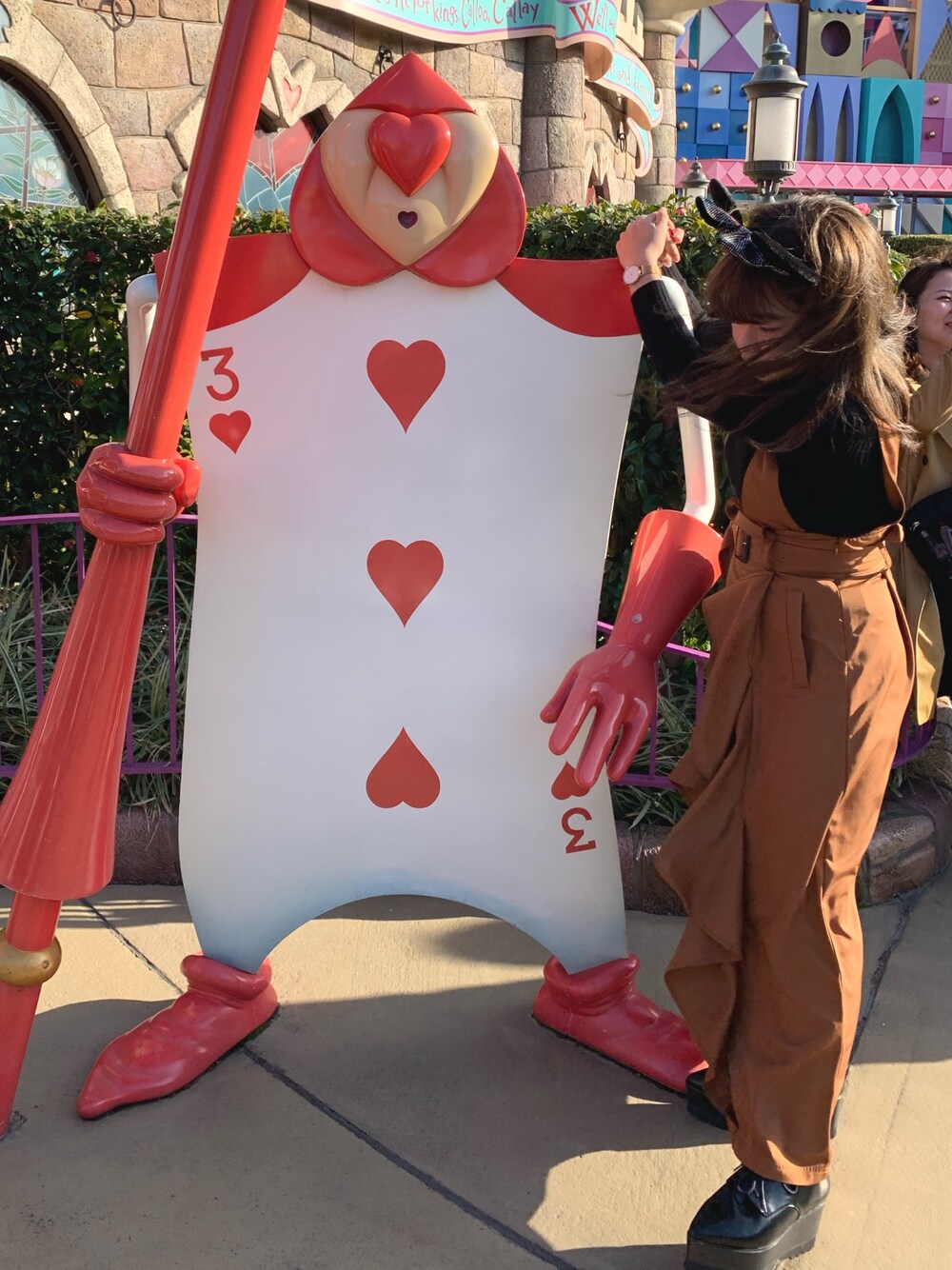 ブラウン系のジャンパースカート、ゴールド系のアナログ腕時計を着用したレディースの春コーディネートの1枚目の写真