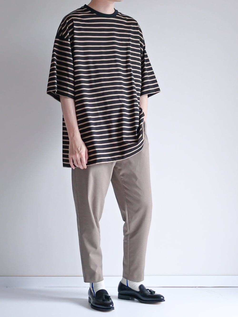 ブルー系のTシャツ/カットソー、ベージュ系のその他パンツ、ブラック系のローファーを着用したメンズの夏コーディネートの1枚目の写真