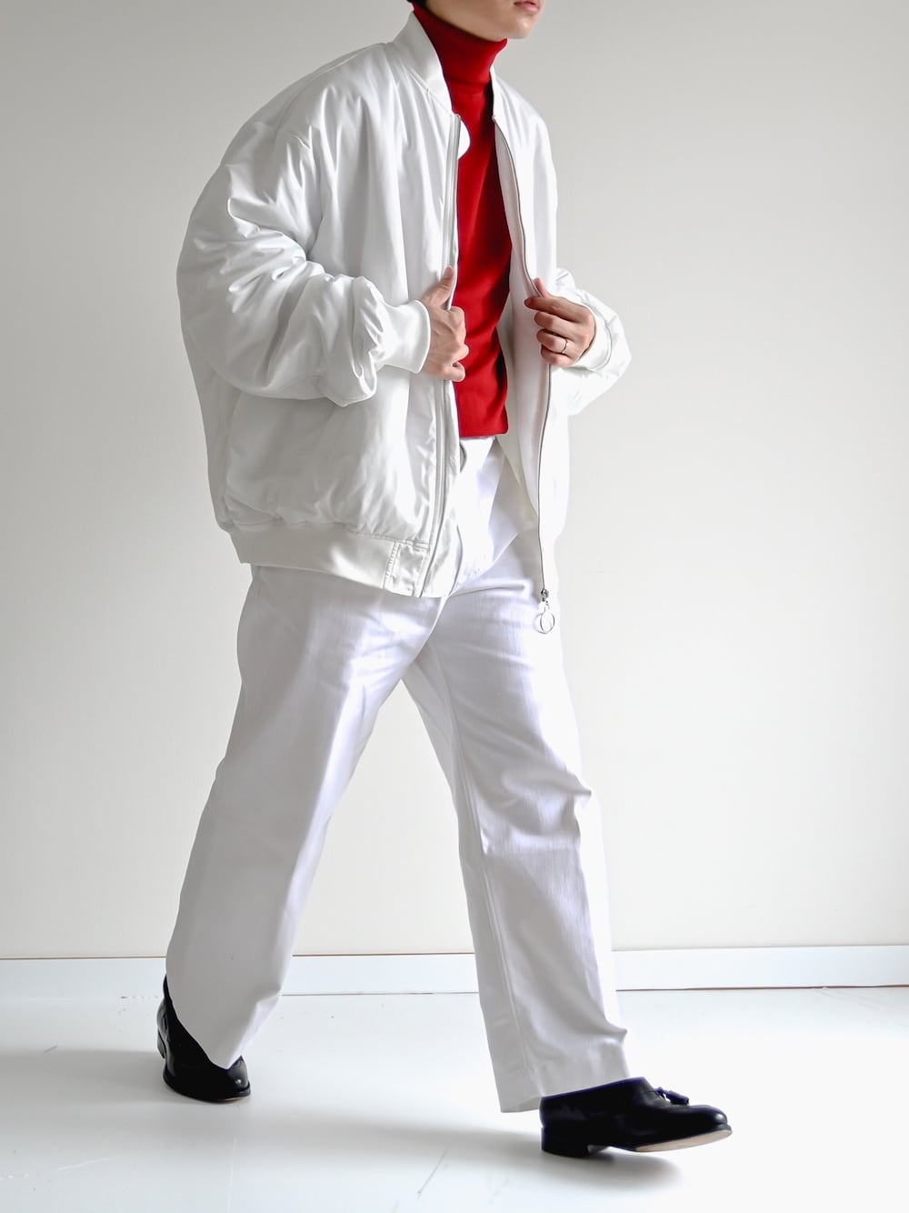 ホワイト系のMA-1、レッド系のニット/セーター、ホワイト系のデニムパンツを着用したメンズの秋コーディネートの1枚目の写真