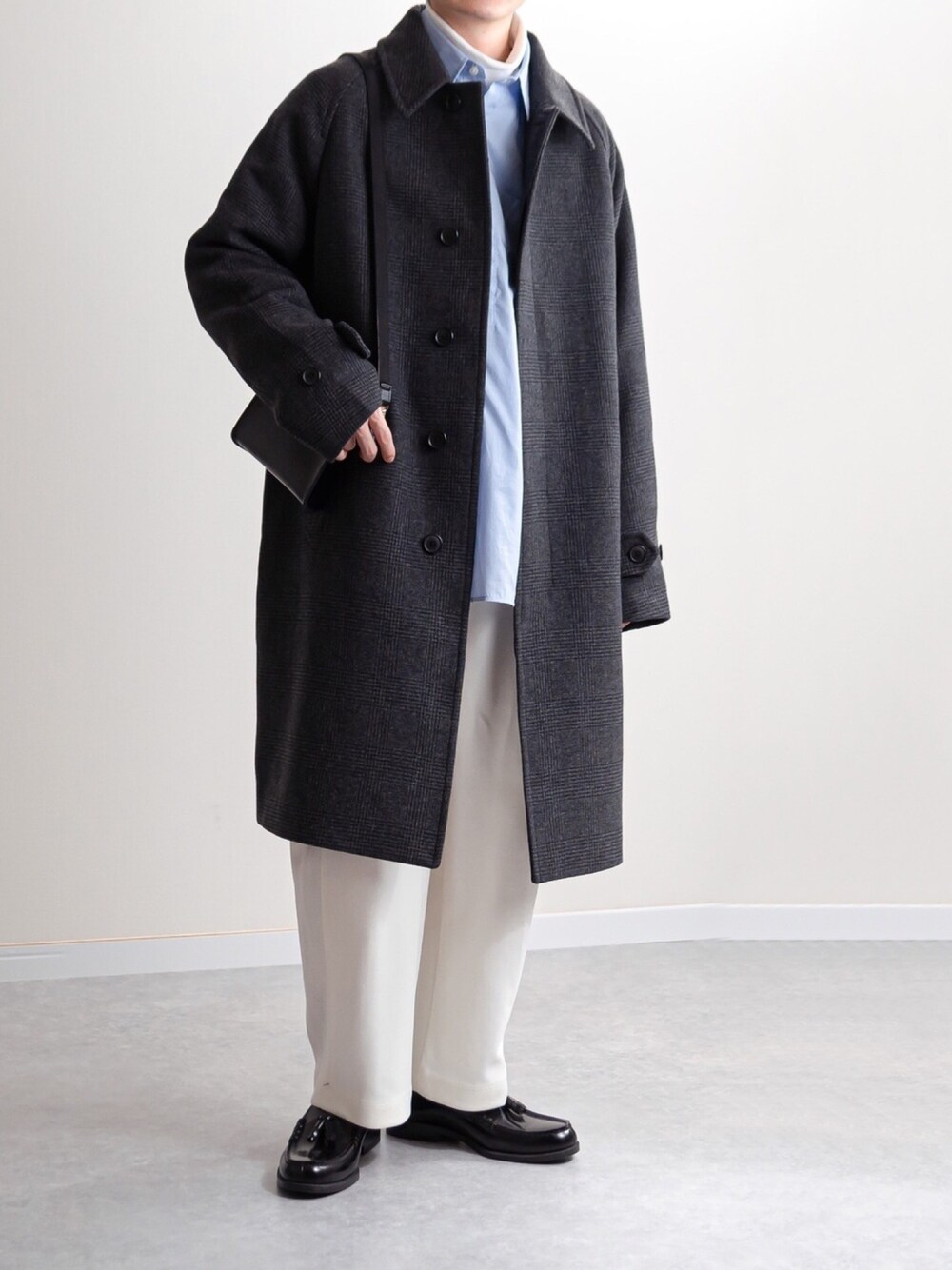 グレー系のステンカラーコート、ホワイト系のその他パンツを着用したメンズの冬コーディネートの1枚目の写真