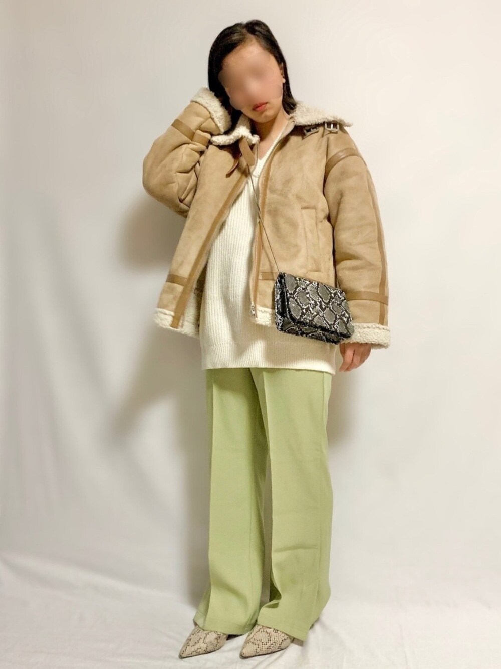 ベージュ系のムートンコート、ホワイト系のニット/セーター、ブラック系のショルダーバッグを着用したレディースの秋コーディネートの1枚目の写真