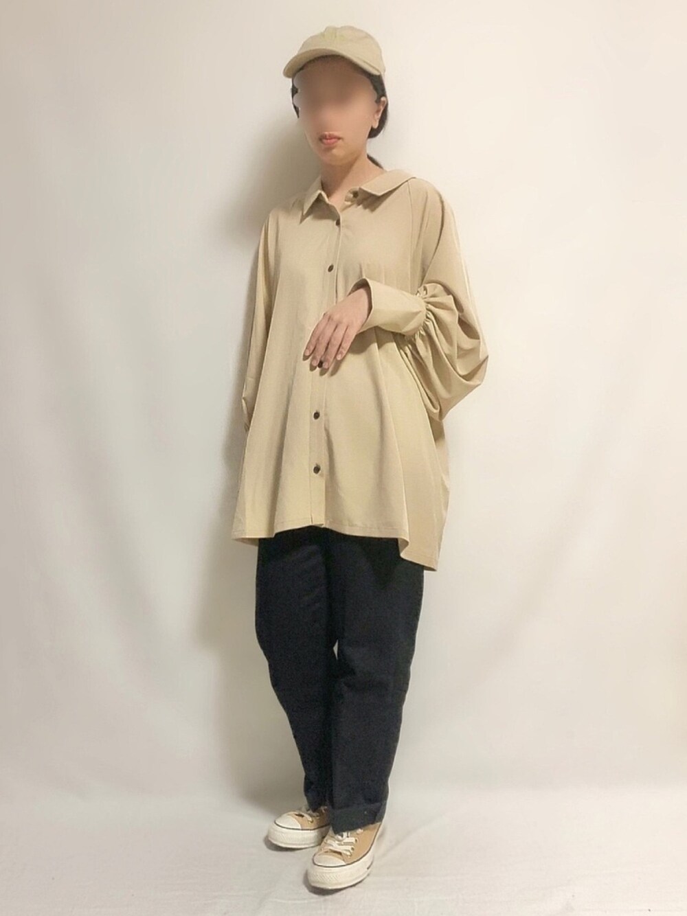 ブラック系のデニムパンツ、ブラウン系のスニーカー、ベージュ系のシャツ/ブラウスを着用したレディースの春コーディネートの1枚目の写真