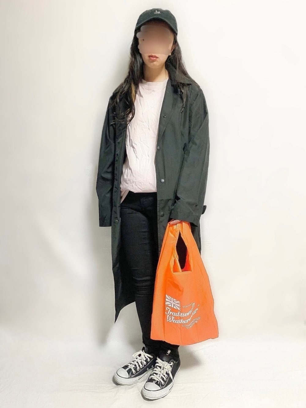 ピンク系のTシャツ/カットソー、オレンジ系のエコバッグ/サブバッグ、ブラック系のパンツを着用したレディースの春コーディネートの1枚目の写真