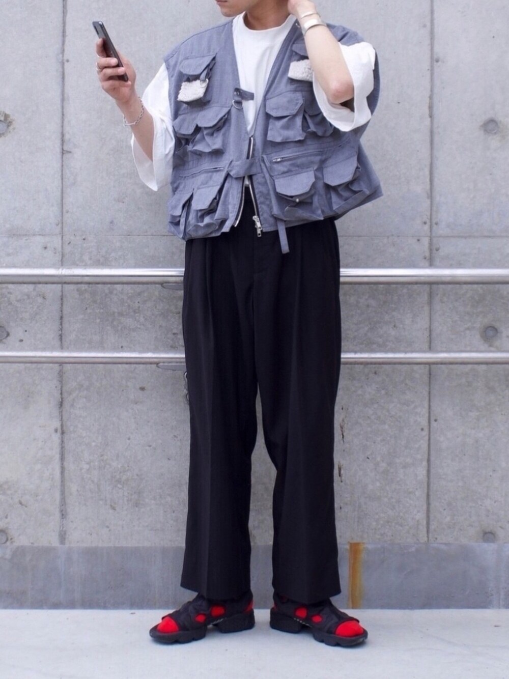 グレー系のベスト、ホワイト系のTシャツ/カットソー、ブラック系のスラックスを着用したメンズの夏コーディネートの1枚目の写真