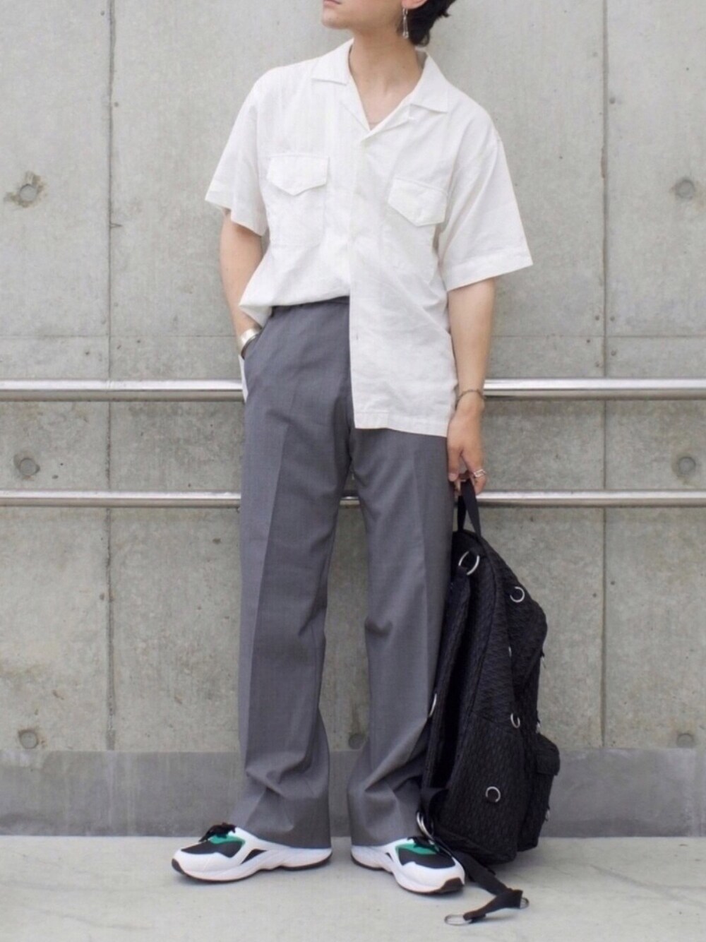 ブラック系のバックパック/リュック、ブラック系のスニーカー、グレー系のスラックスを着用したメンズの夏コーディネートの1枚目の写真