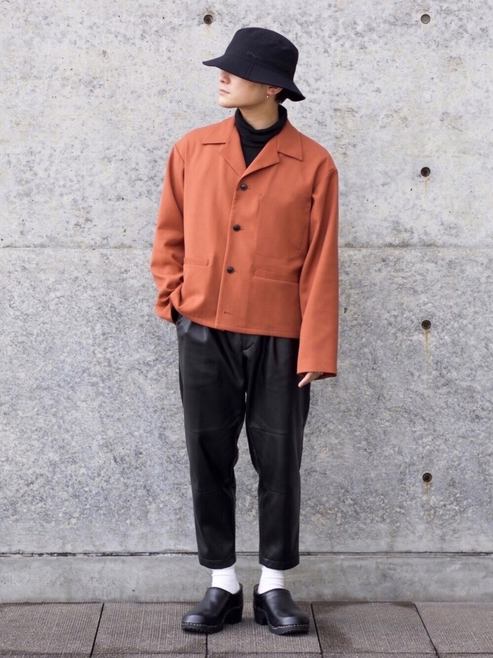 ブラウン系のブルゾン、ブラック系のTシャツ/カットソー、ブラック系のパンツを着用したメンズの春コーディネートの1枚目の写真