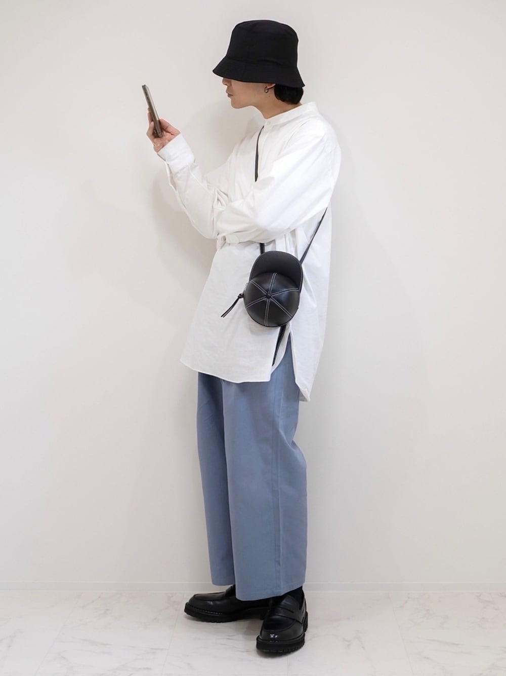 ホワイト系のシャツ/ブラウス、ブラック系のショルダーバッグ、ブルー系のチノパンツを着用したメンズの春コーディネートの1枚目の写真
