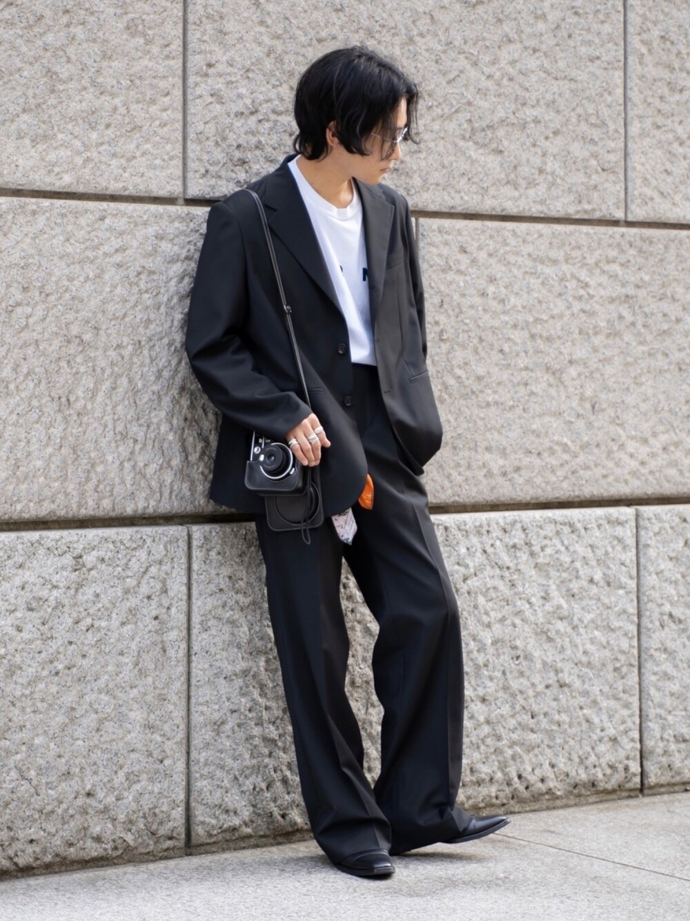 ブラック系のテーラードジャケット、ブラック系のスラックス、ホワイト系のTシャツ/カットソーを着用したメンズの春コーディネートの1枚目の写真