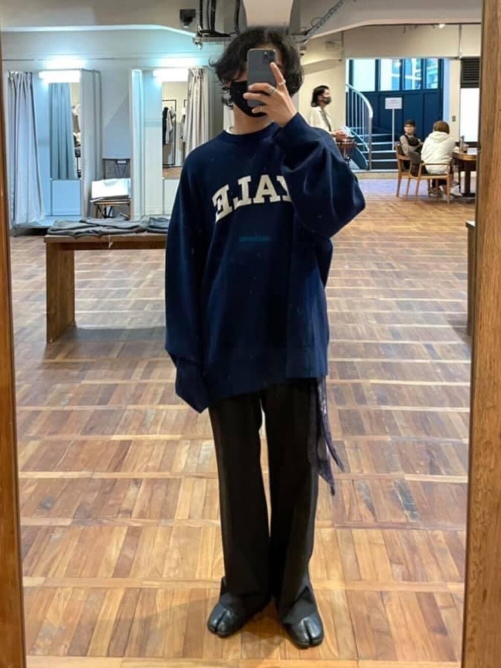 ブラック系のスラックス、ブルー系のニット/セーター、ブラック系のブーツを着用したメンズの夏コーディネートの1枚目の写真