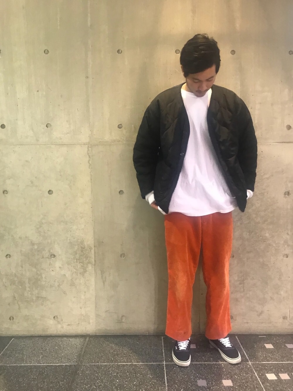 ブラック系のブルゾン、オレンジ系のパンツ、ホワイト系のTシャツ/カットソーを着用したメンズの秋コーディネートの1枚目の写真