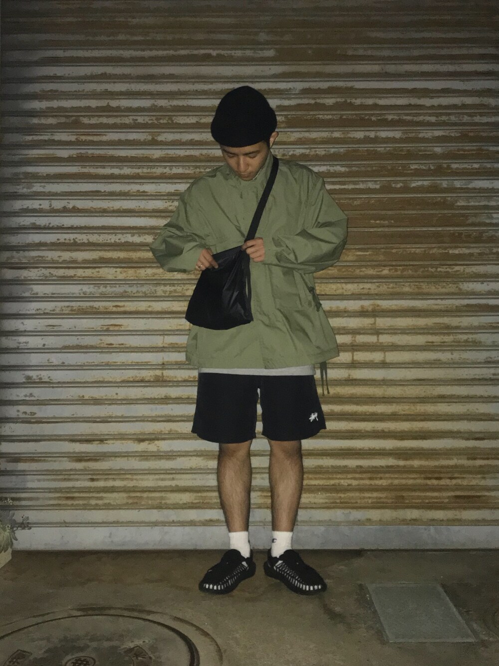 ブラック系のその他パンツ、ブラック系のサンダル、グリーン系のミリタリージャケットを着用したメンズの春コーディネートの1枚目の写真