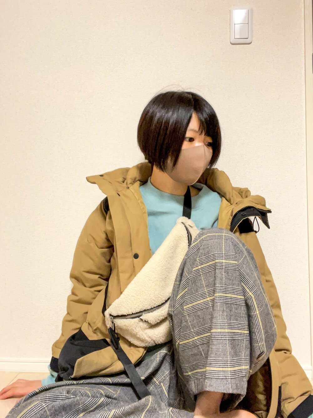 ベージュ系のダウンジャケット/コート、ベージュ系のボディバッグ/ウエストポーチ、グレー系のその他パンツを着用したレディースの冬コーディネートの1枚目の写真