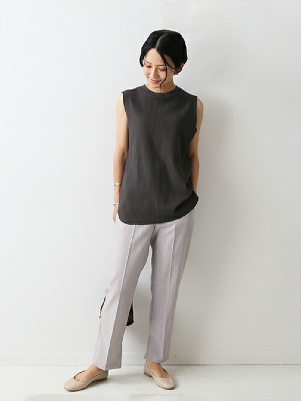 グレー系のスラックス、グレー系のTシャツ/カットソー、ブラウン系のショルダーバッグを着用したレディースの夏コーディネートの1枚目の写真