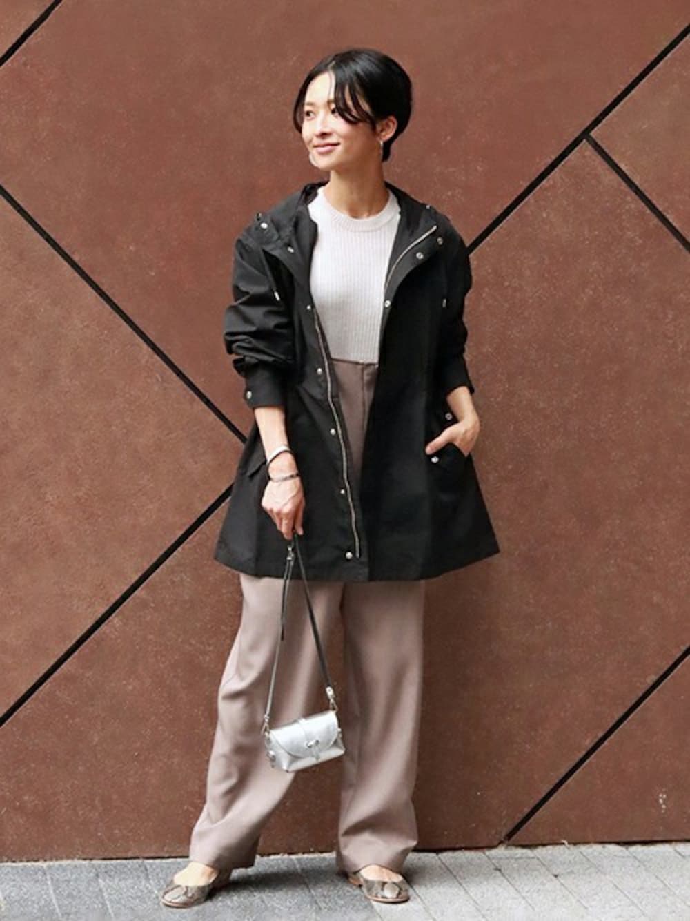 ブラック系のマウンテンパーカー、ベージュ系のニット/セーター、ベージュ系のサロペット/オーバーオールを着用したレディースの秋コーディネートの1枚目の写真