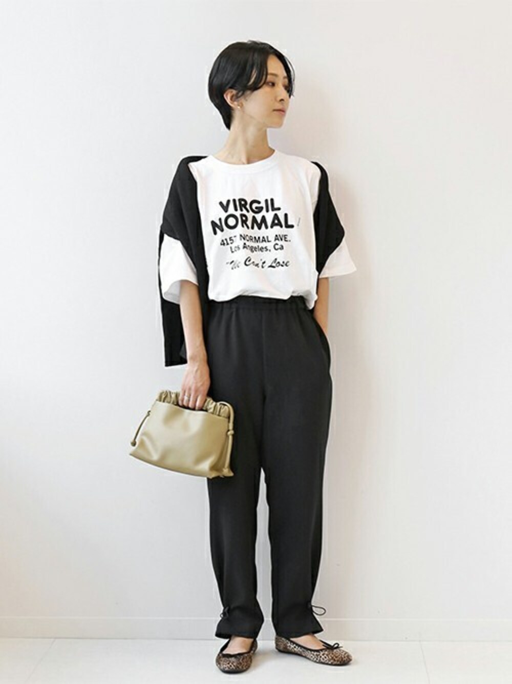 ホワイト系のTシャツ/カットソー、ブラック系のその他パンツ、グリーン系のショルダーバッグを着用したレディースの秋コーディネートの1枚目の写真