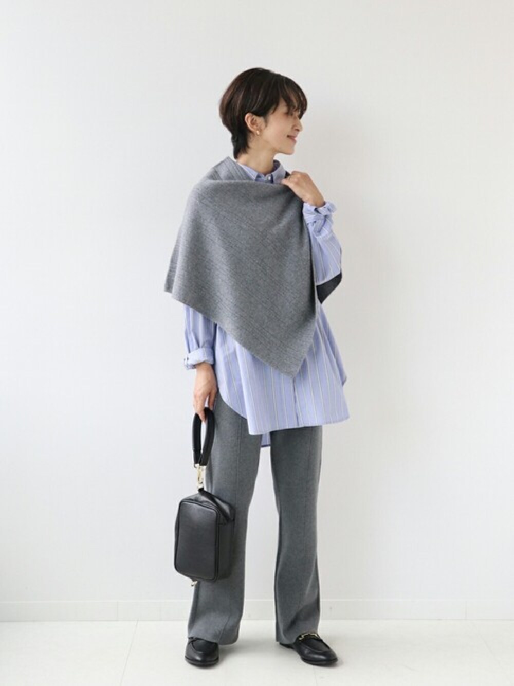グレー系のニット/セーター、ブルー系のシャツ/ブラウス、グレー系のその他パンツを着用したレディースの秋コーディネートの1枚目の写真