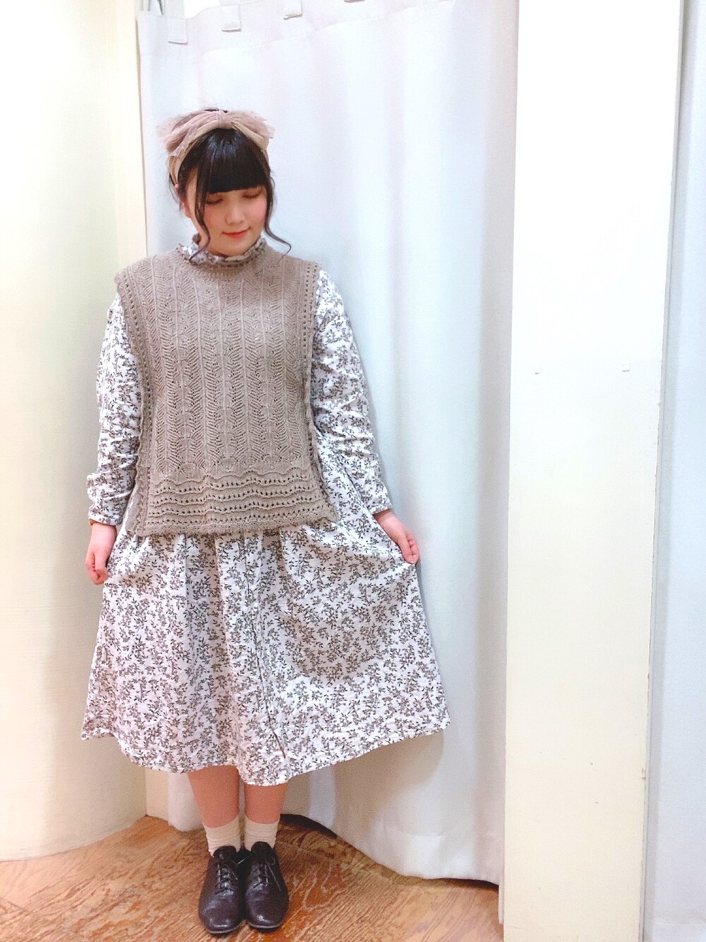 パープル系のワンピース、ベージュ系のニット/セーター、ブラウン系のドレスシューズを着用したレディースの冬コーディネートの1枚目の写真