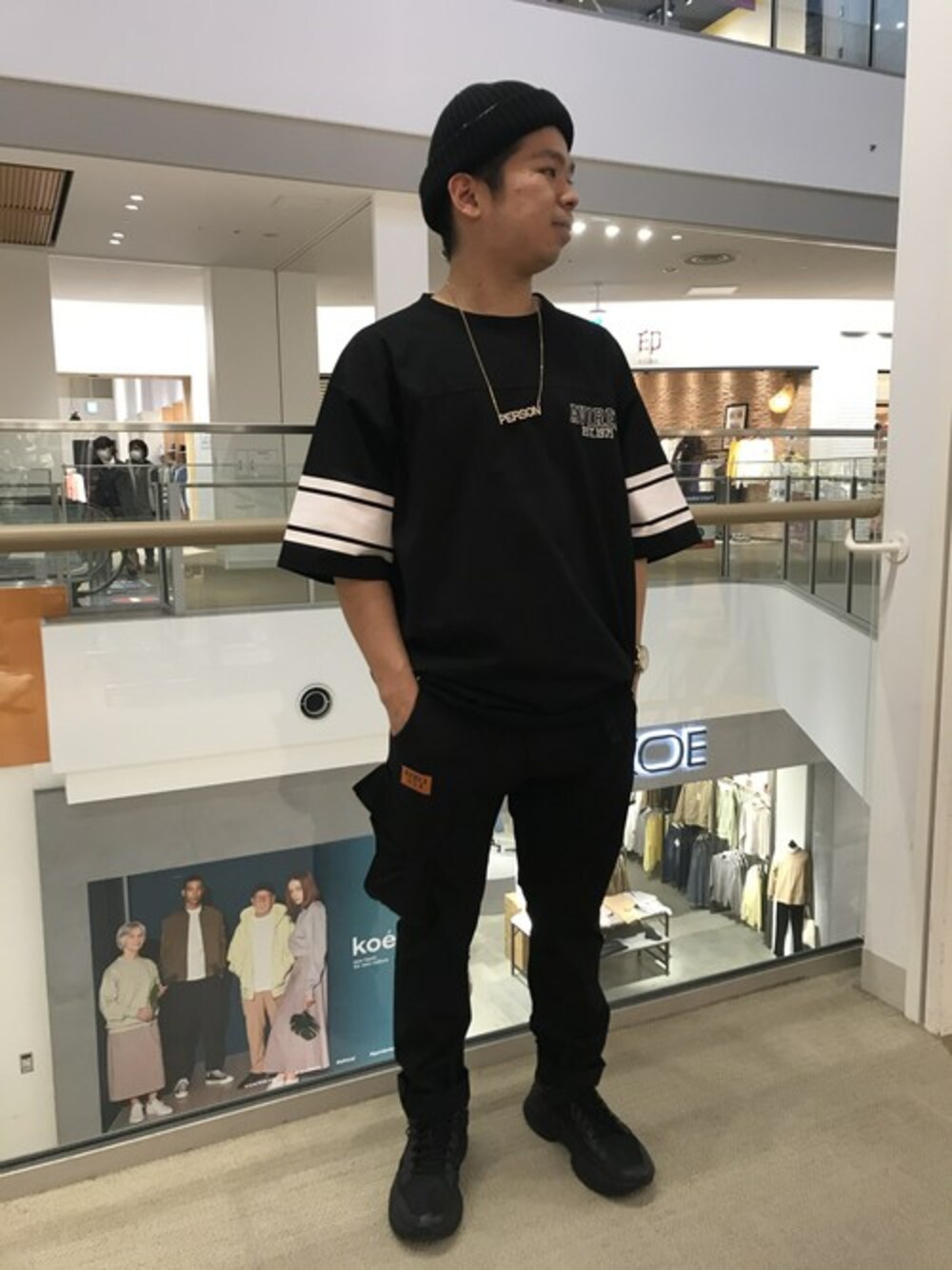 「ブラック、ニット帽、ブラックコーデ、ストリート、AVIREX、オールブラック、春、春コーデ、カジュアルコーデ、AVIREX心斎橋」｜「AVIREXのクールマックス ルーズフィット フットボールTシャツ/ COOLMAX LOOSE FIT FOOT BALL T-SHIRT（Tシャツ/カットソー、ブラック系）」を使った、南慎也さん（メンズ・166cm）の春コーディネートの1枚目の写真