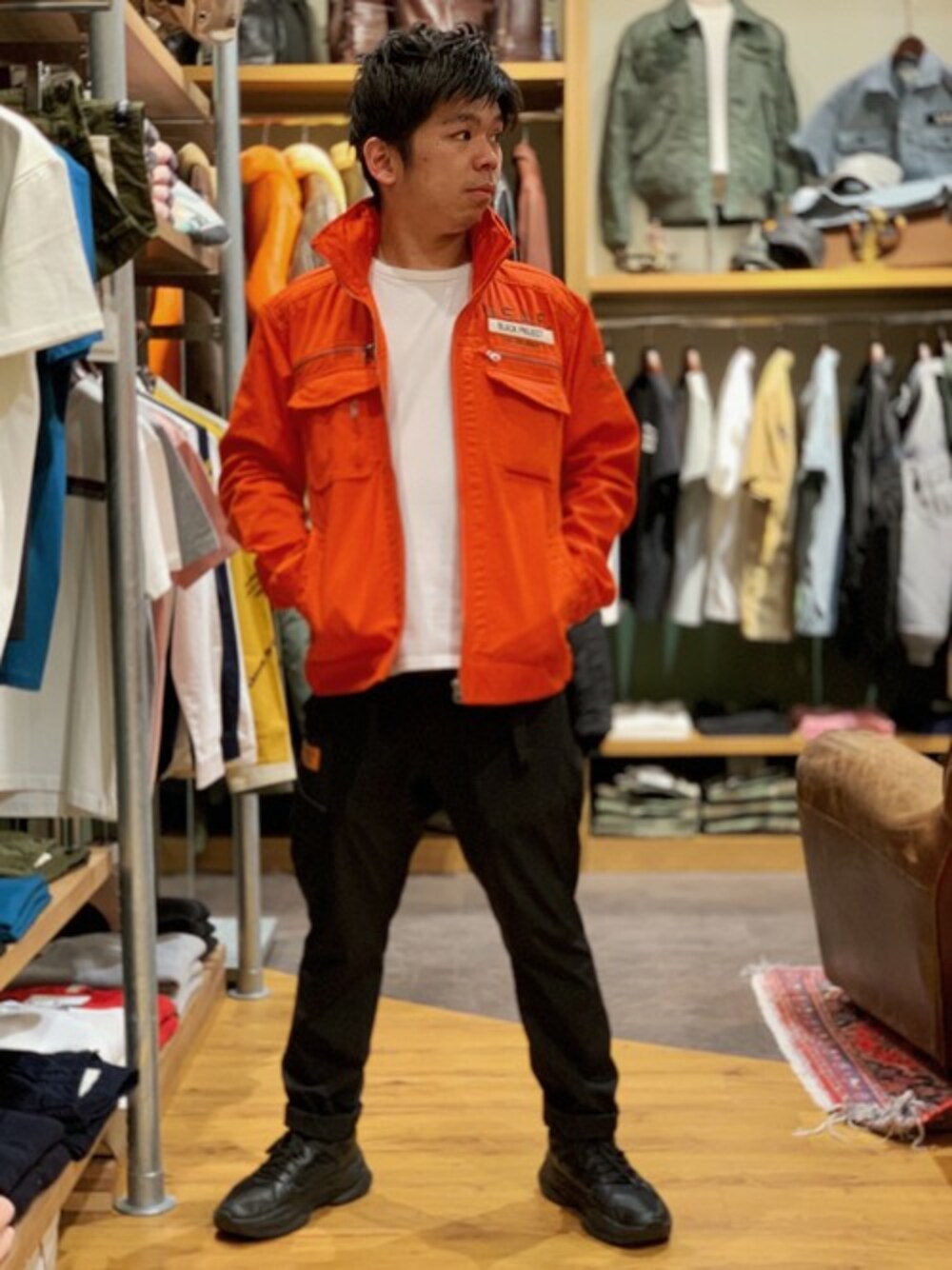 「スニーカー、ミリタリー、AVIREX、オレンジ、ストレッチパンツ、ミリタリージャケット、新作、春コーデ、AVIREXBelle、AVIREX心斎橋」｜「AVIREXの【直営店限定】ストレッチカーゴパンツ/STRETCH CARGO PANTS（カーゴパンツ、ブラック系）」を使った、南慎也さん（メンズ・166cm）の春コーディネートの1枚目の写真