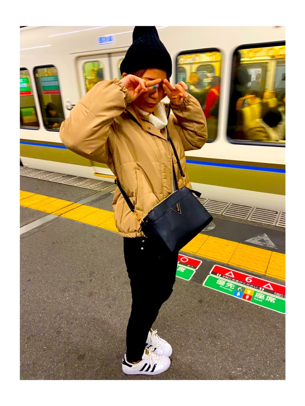 ベージュ系のダウンジャケット/コート、ブラック系のその他パンツ、ホワイト系のスニーカーを着用したレディースの冬コーディネートの1枚目の写真