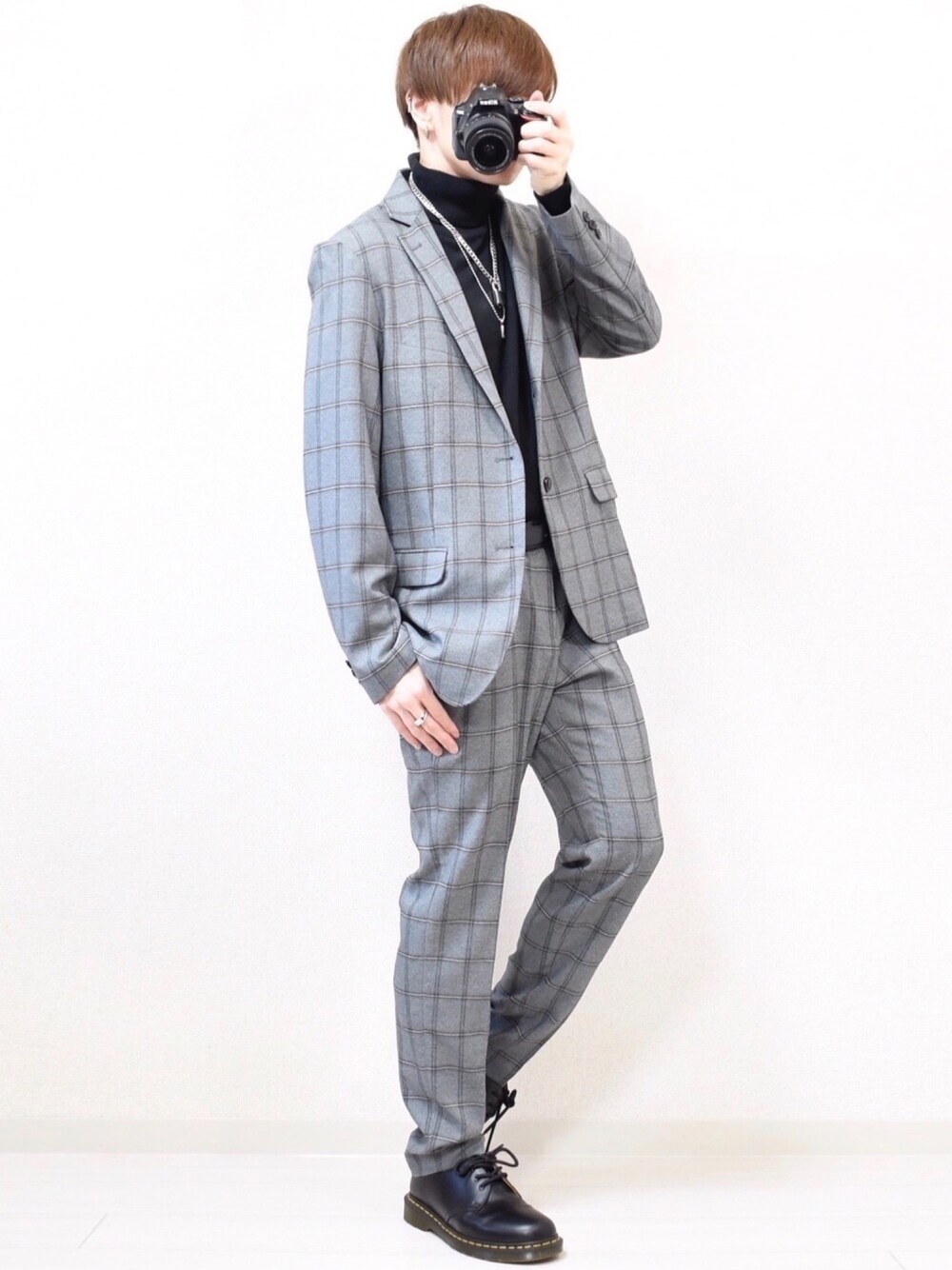 グレー系のテーラードジャケット、ブラック系のニット/セーター、グレー系のパンツを着用したメンズの夏コーディネートの1枚目の写真