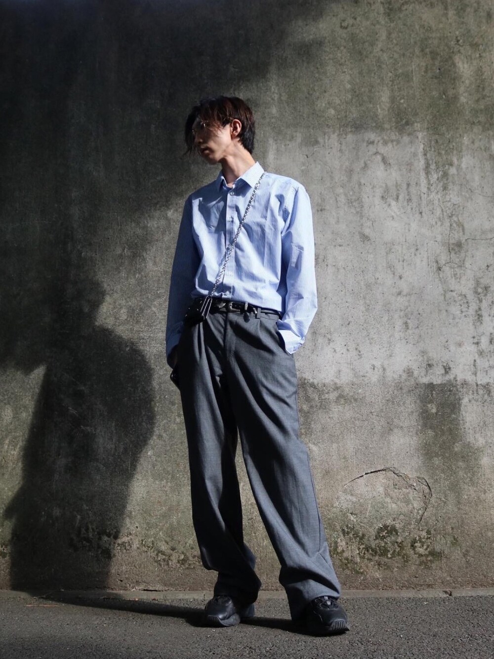 グレー系のスラックス、ブラック系のスニーカー、ブルー系のシャツ/ブラウスを着用したメンズの秋コーディネートの1枚目の写真