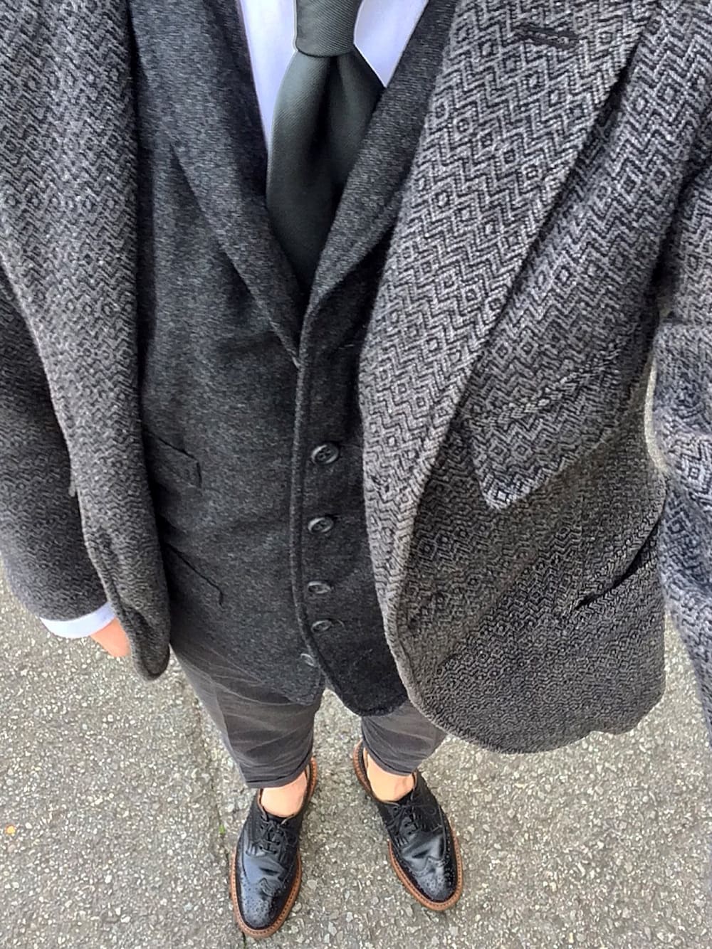 グレー系のジャケット/アウター、グレー系のスーツベスト、ブラック系のドレスシューズを着用したメンズの秋コーディネートの1枚目の写真